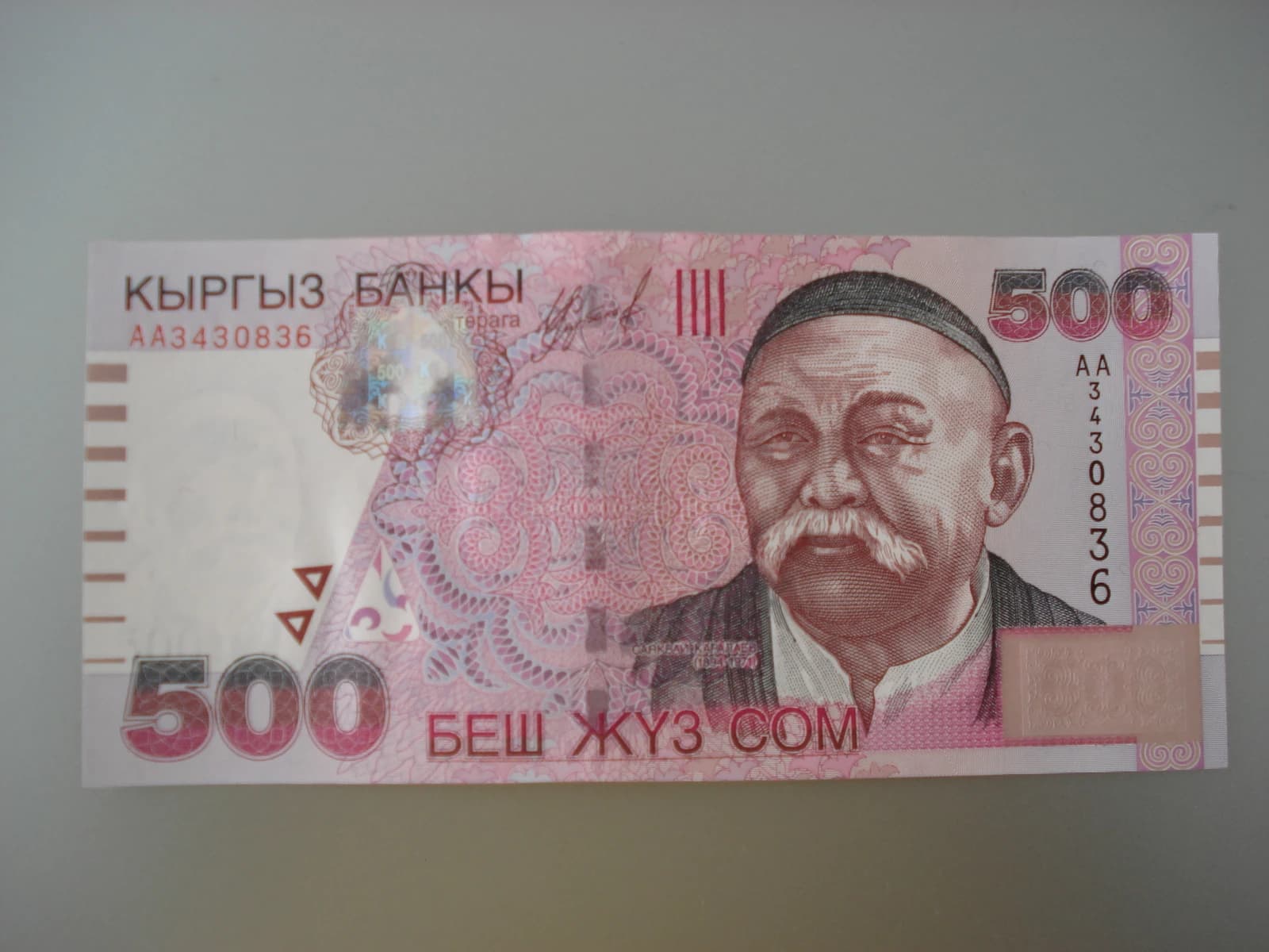A close-up of a 500 Kyrgyz som banknote showing the portrait of a man.