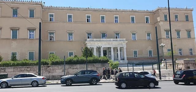 Royal Palace of Athens, housing the Hellenic Parliament, with street traffic in front.