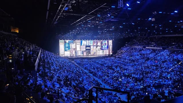 Jensen Huang, Nvidia CEO, speaks on a stage at a large tech conference.