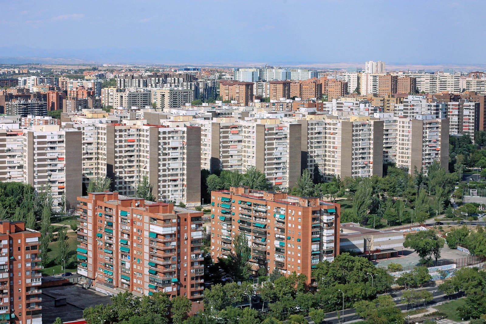 An aerial view shows numerous residential buildings, some with green awnings, in Madrid, Spain.