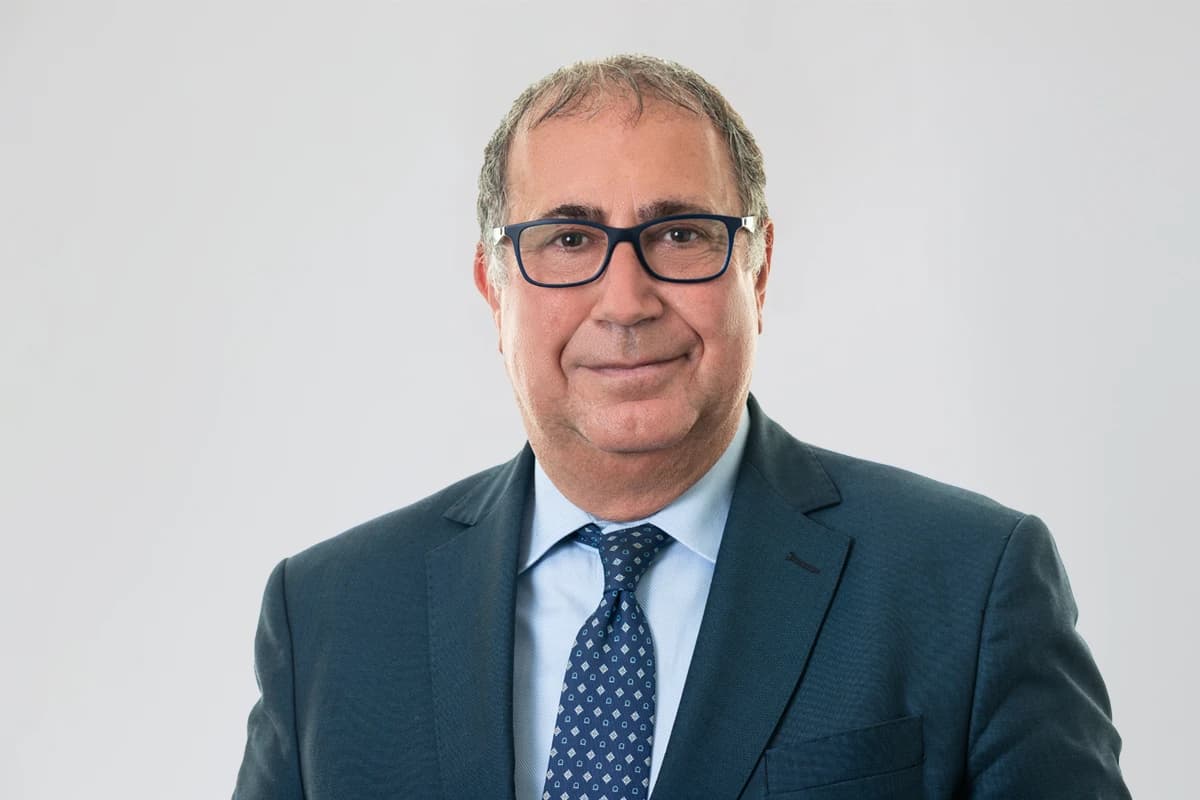 Manfredi Selvaggi, a man wearing glasses, suit, and tie, looking at the camera.