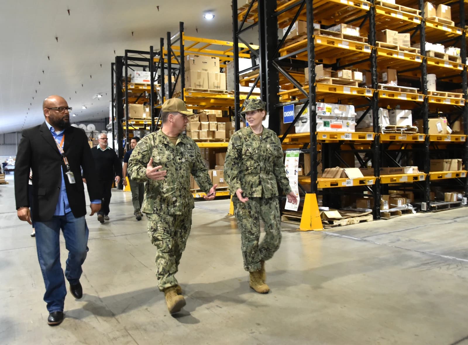NAVSUP commander touring a fleet logistics center warehouse in Italy.