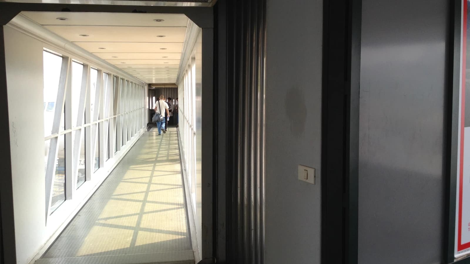 Travelers walking down a jet bridge at Noi Bai International Airport, Hanoi.