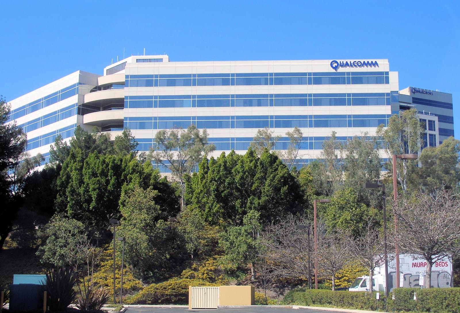 Exterior view of Qualcomm's corporate headquarters building with its logo visible on the roof.