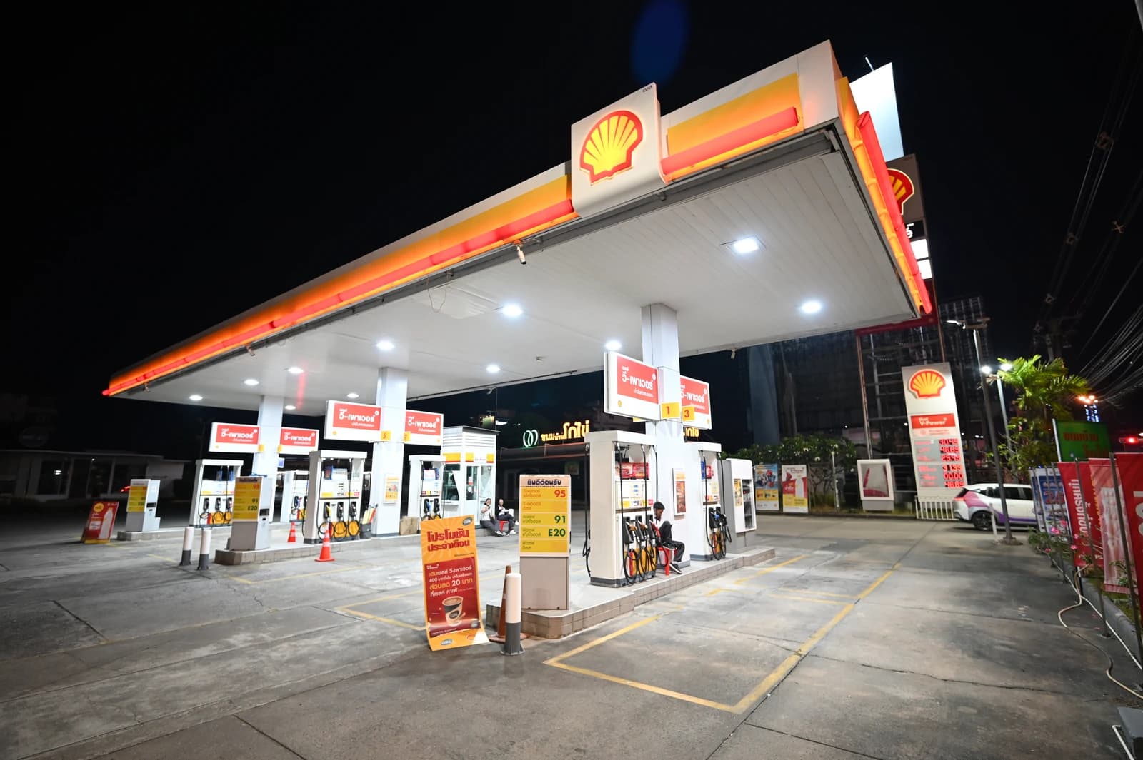 Empty Shell petrol station at night, brightly lit, pumps ready for customers.