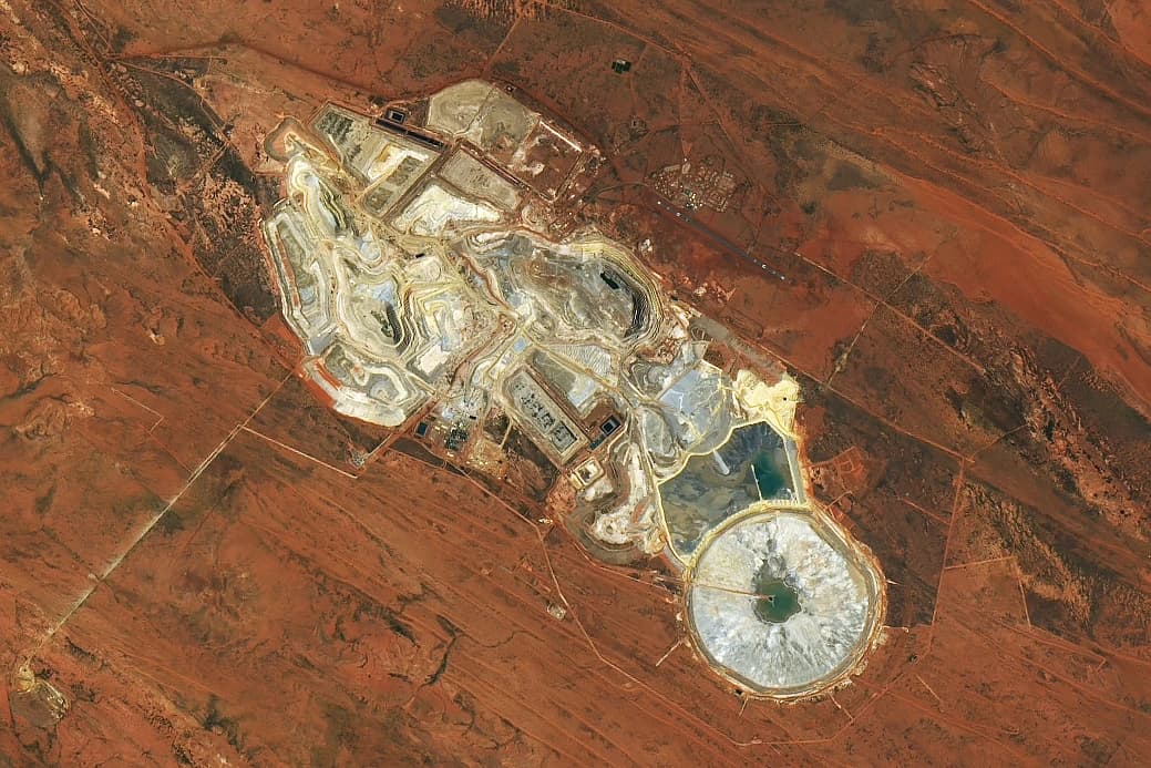 Aerial view of the Telfer Mine site, showing open pits and surrounding red earth.