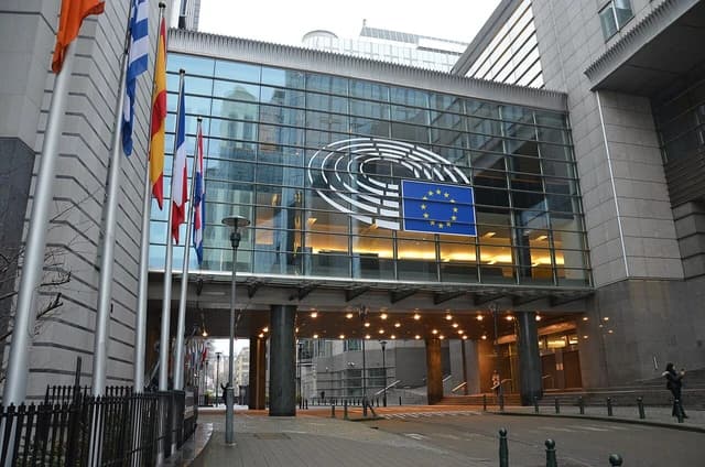 Exterior view of the European Parliament building in Brussels with flags of European nations.
