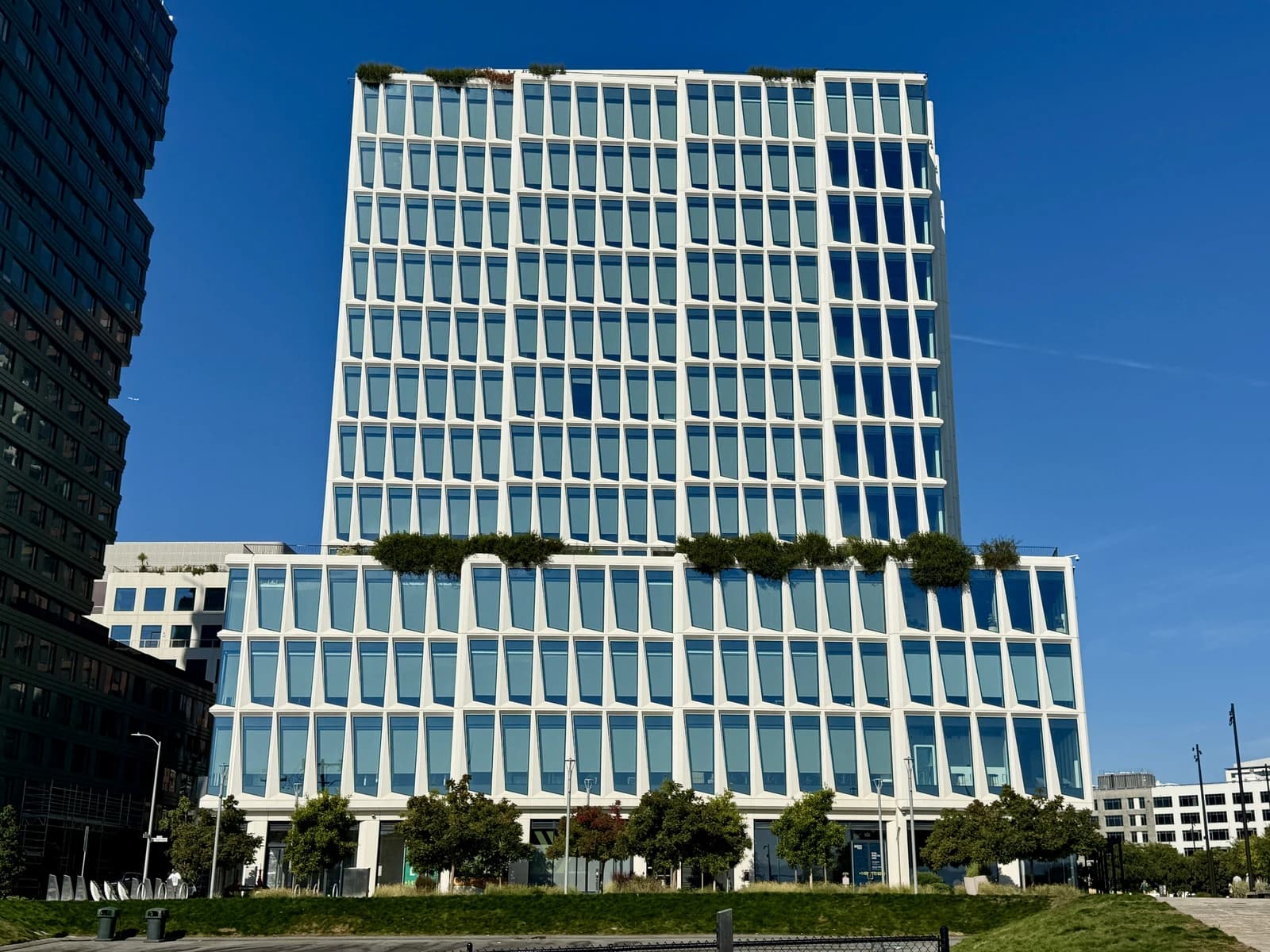 The Visa headquarters building, a modern white high-rise with many windows, under a clear blue sky.