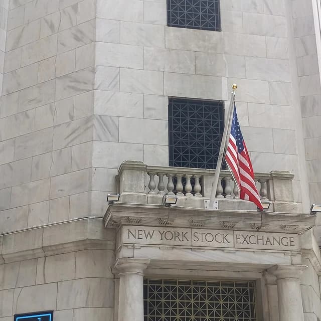 American flag flies from a pole on the facade of the New York Stock Exchange.