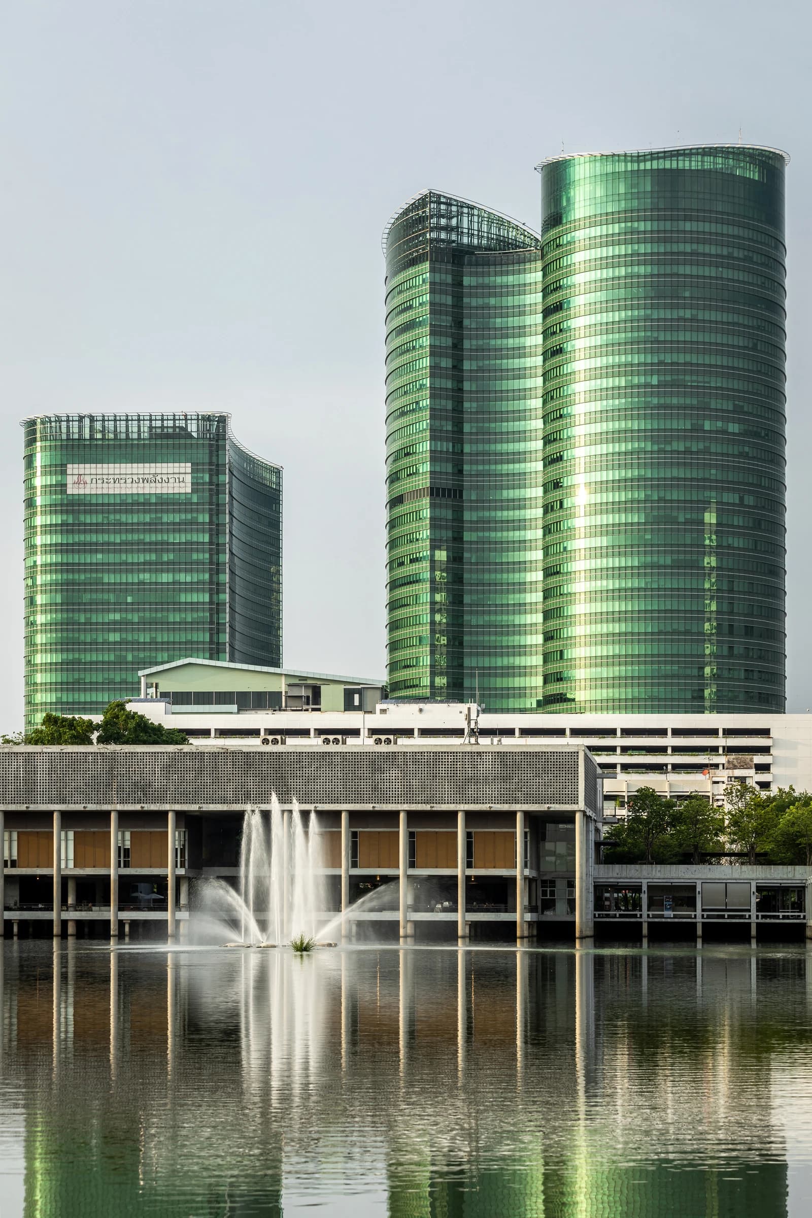 Building of the Ministry of Energy headquarters reflecting on a body of water with fountains.