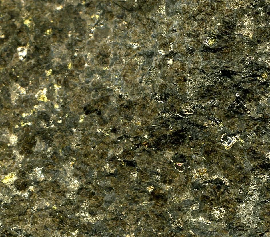Close-up of sulfidic bronzitite rock showing metallic flecks of platinum and palladium ore.