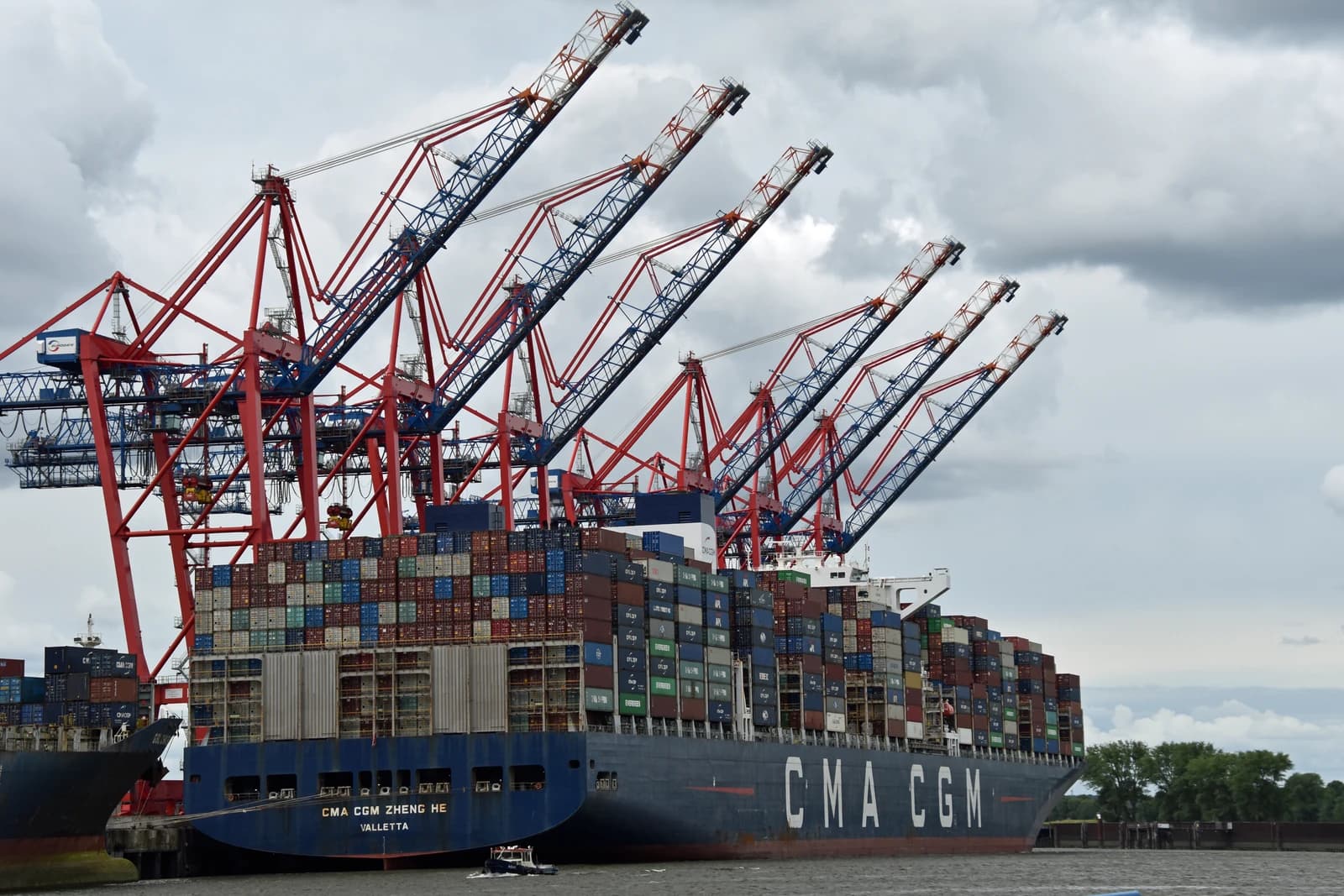CMA CGM Zheng He container ship docked in Hamburg port with cranes.