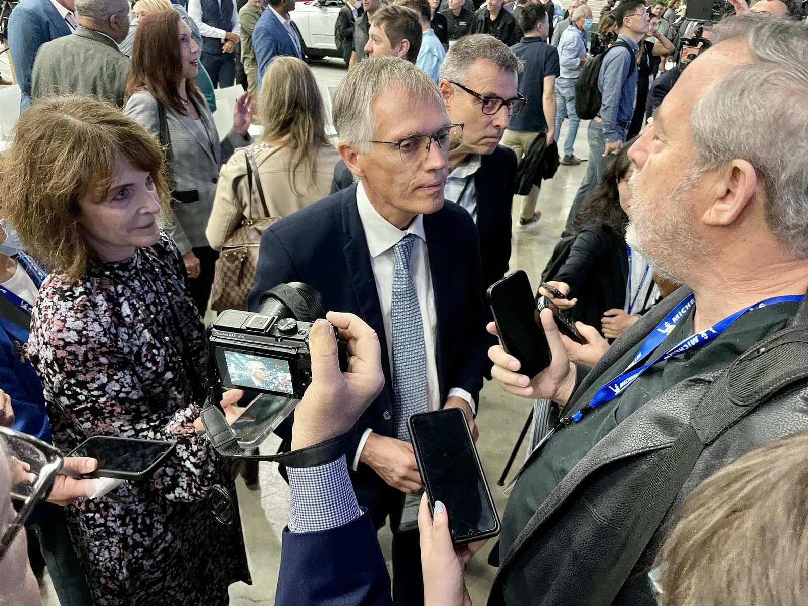 Carlos Tavares, CEO of Stellantis, engaging with individuals holding cameras and phones at an event.