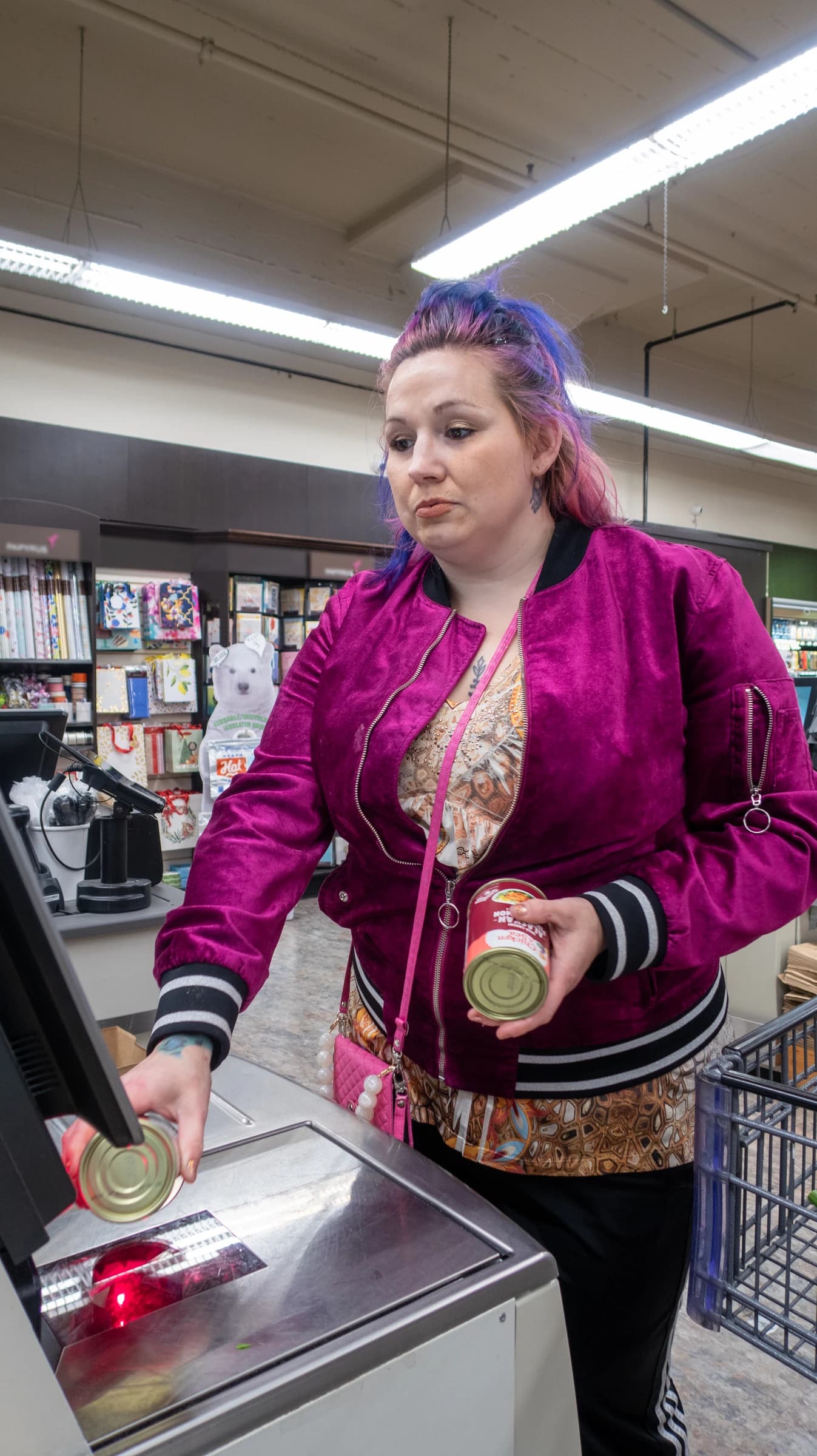 Woman scans a can of food at a grocery store checkout in Seattle, Washington.
