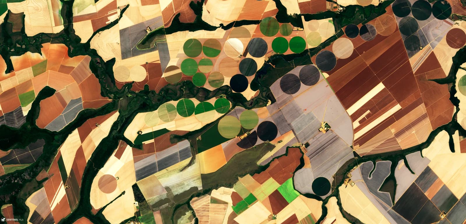 Aerial view of diverse agricultural fields in Brazil, including circular irrigation patterns.