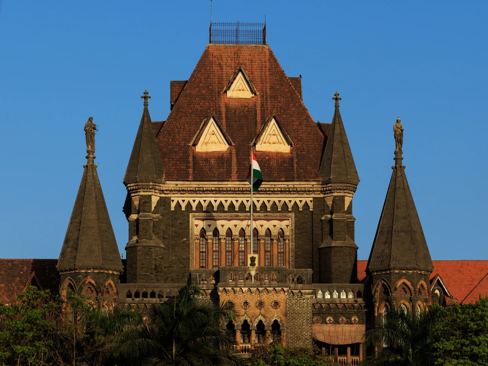 Exterior facade of the Bombay High Court building with a clear blue sky.