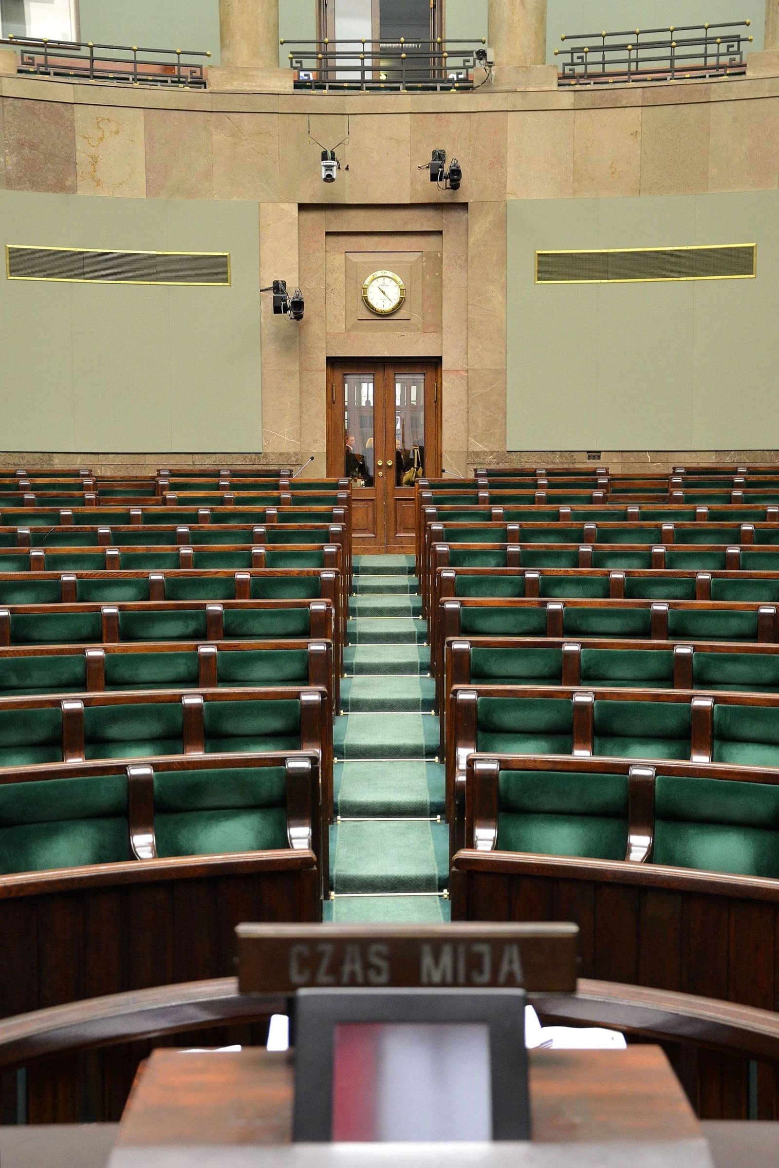 Interior of the Sejm Plenary Hall, Poland, viewed from the rostrum showing rows of green seats.