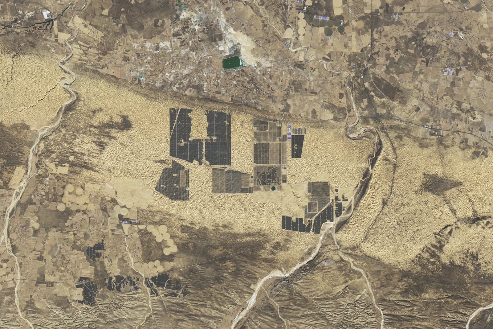 Aerial view of solar panel installations in a desert landscape in China.