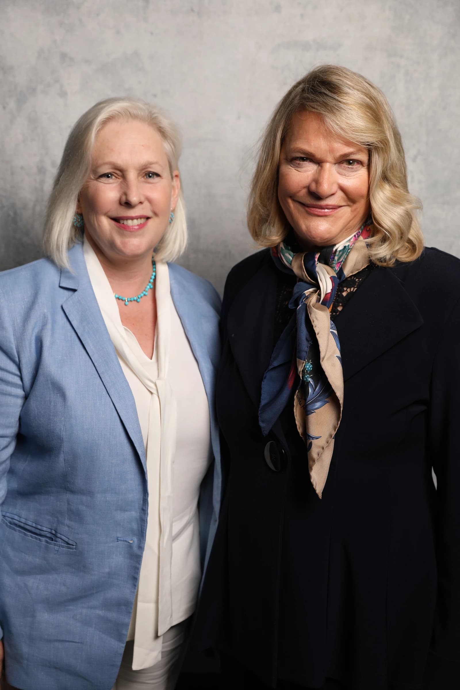 Kristen Gillibrand and Cynthia Lummis standing side-by-side, looking towards the camera.