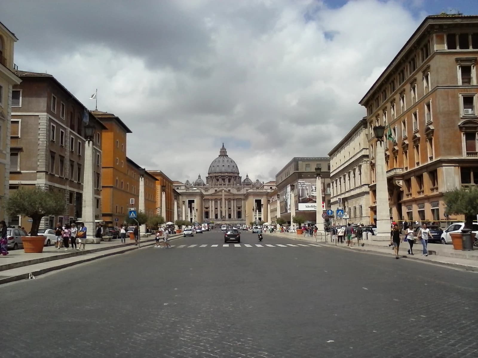 A wide street in Rome, Italy, with St. Peter's Basilica visible in the distance.
