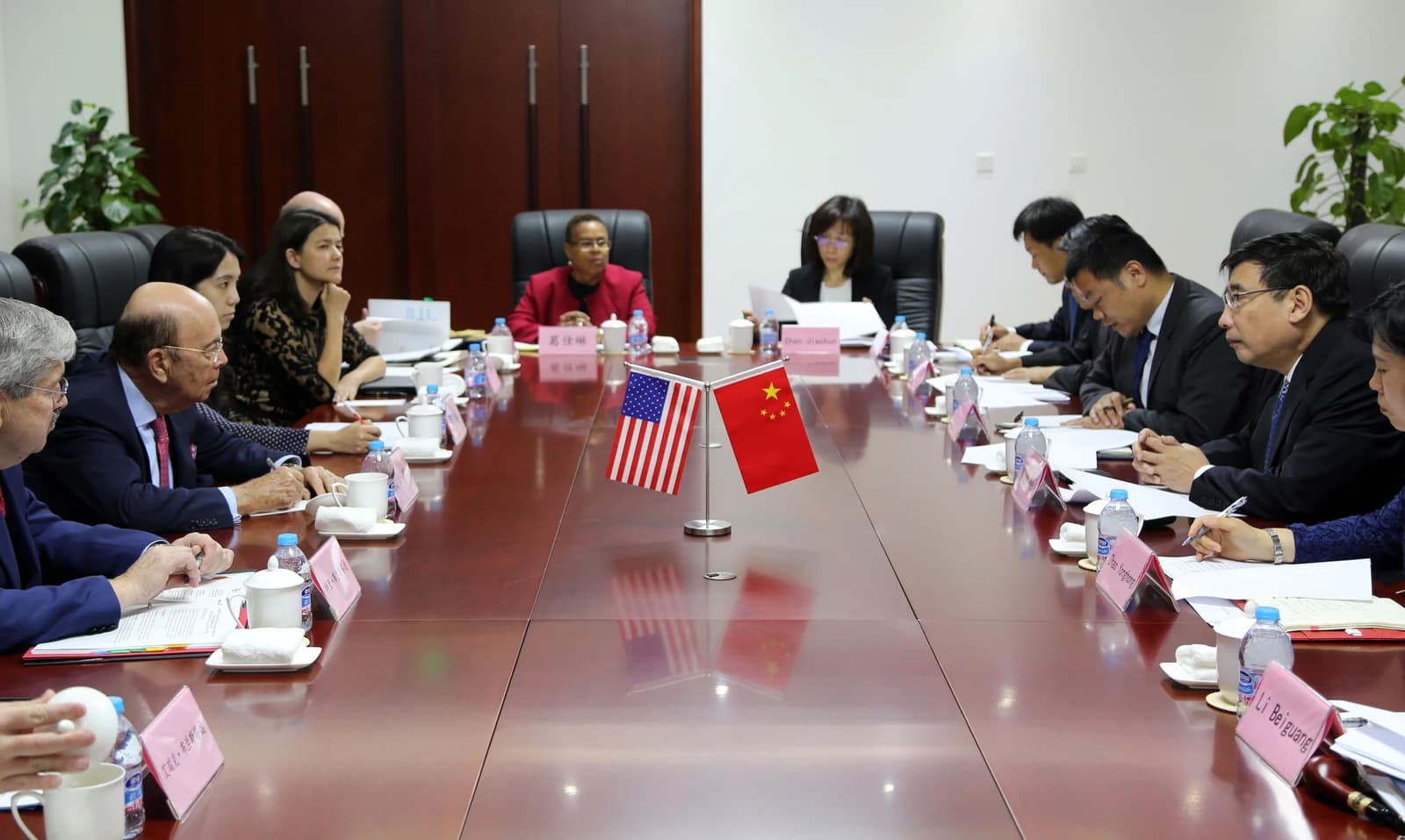 Secretary Ross and Minister Miao Wei attend a meeting in a conference room.