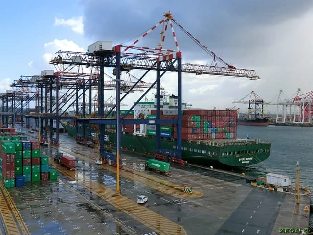 Cargo ship MV Ever Refine docked at Durban Container Terminal under loading cranes.