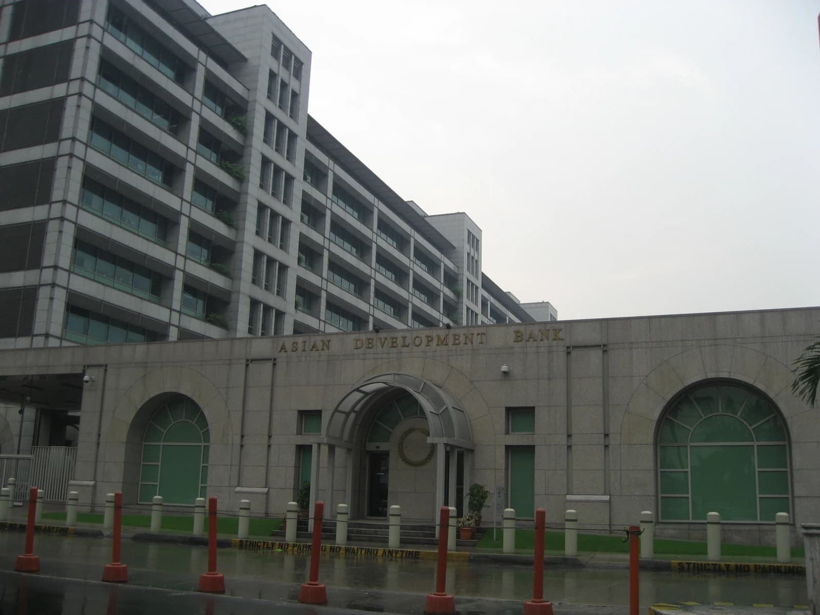 Exterior of the Asian Development Bank headquarters building with its name inscribed above the entrance.