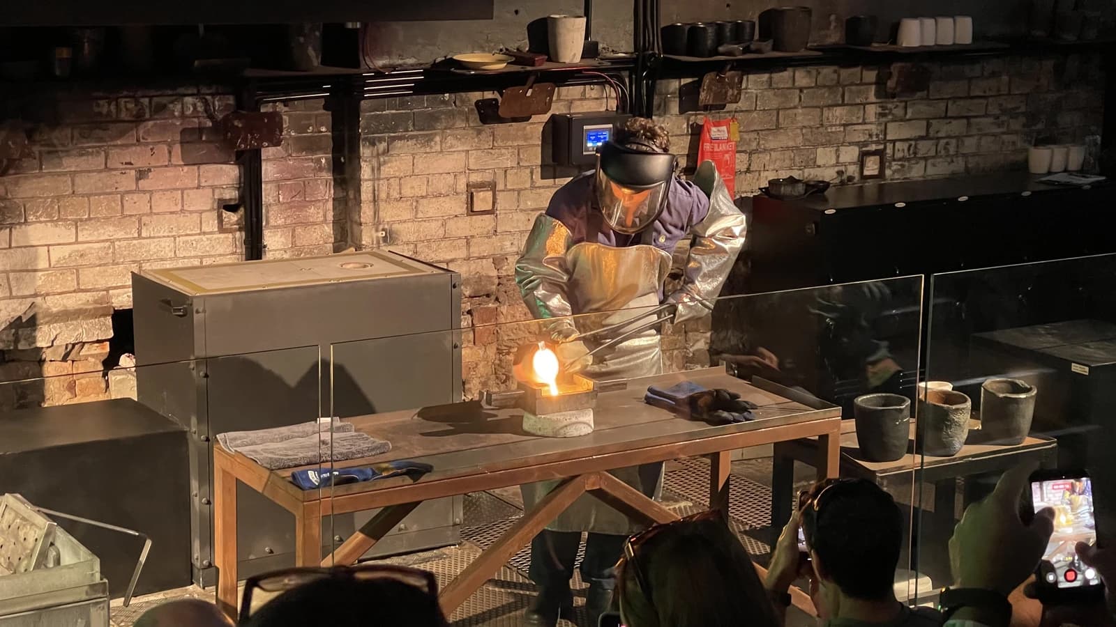 Perth Mint worker in protective gear pouring molten gold into a mold.