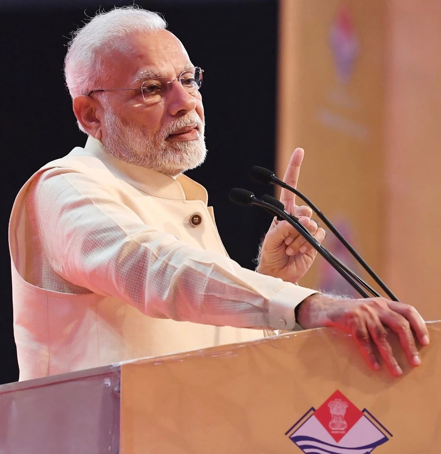 Narendra Modi, Prime Minister of India, speaking at a podium with microphones.