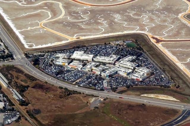 Aerial view of the Facebook campus in Menlo Park, California, with numerous buildings and parking lots.
