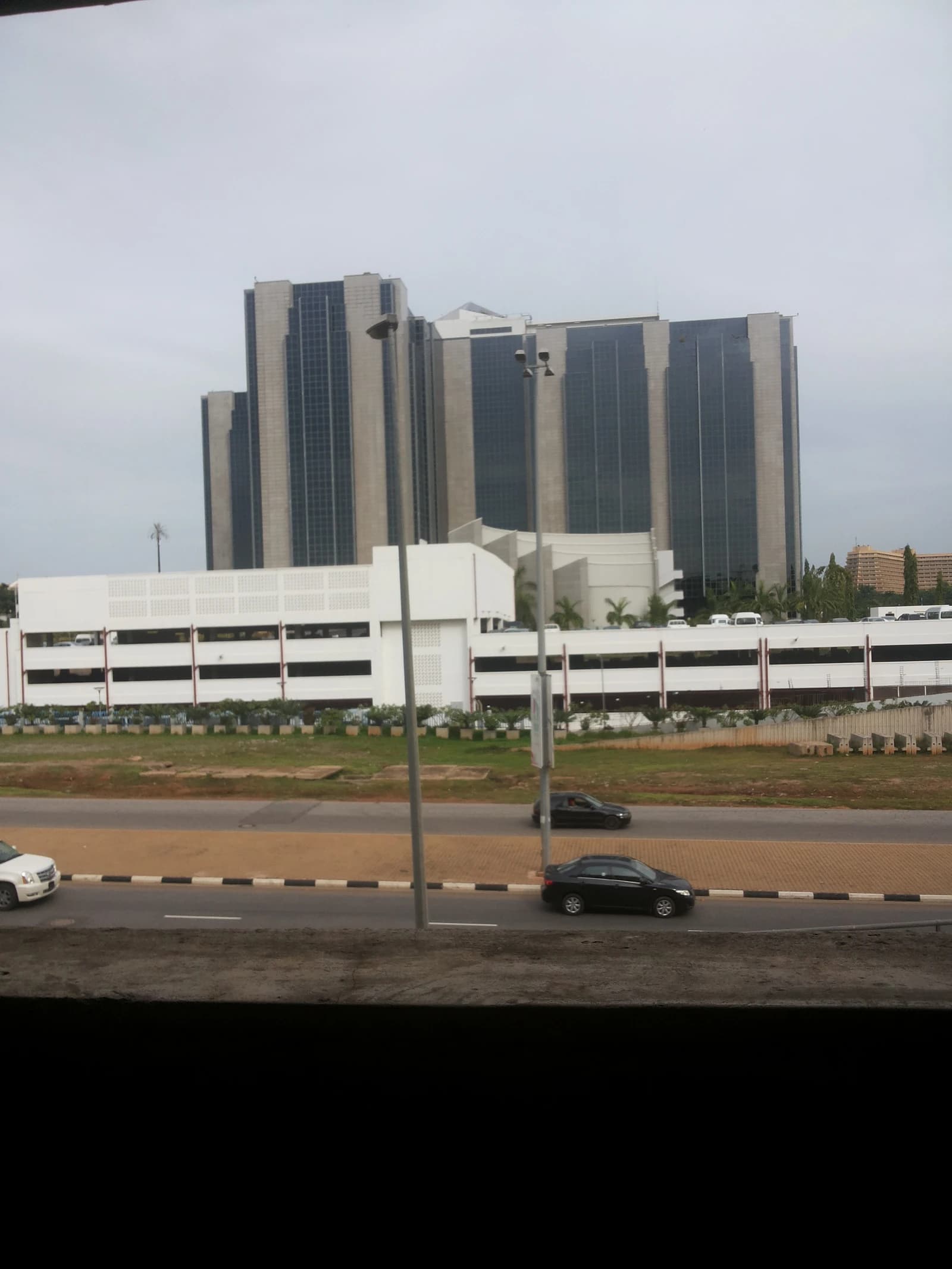 Central Bank of Nigeria headquarters building, a tall structure with a white base.