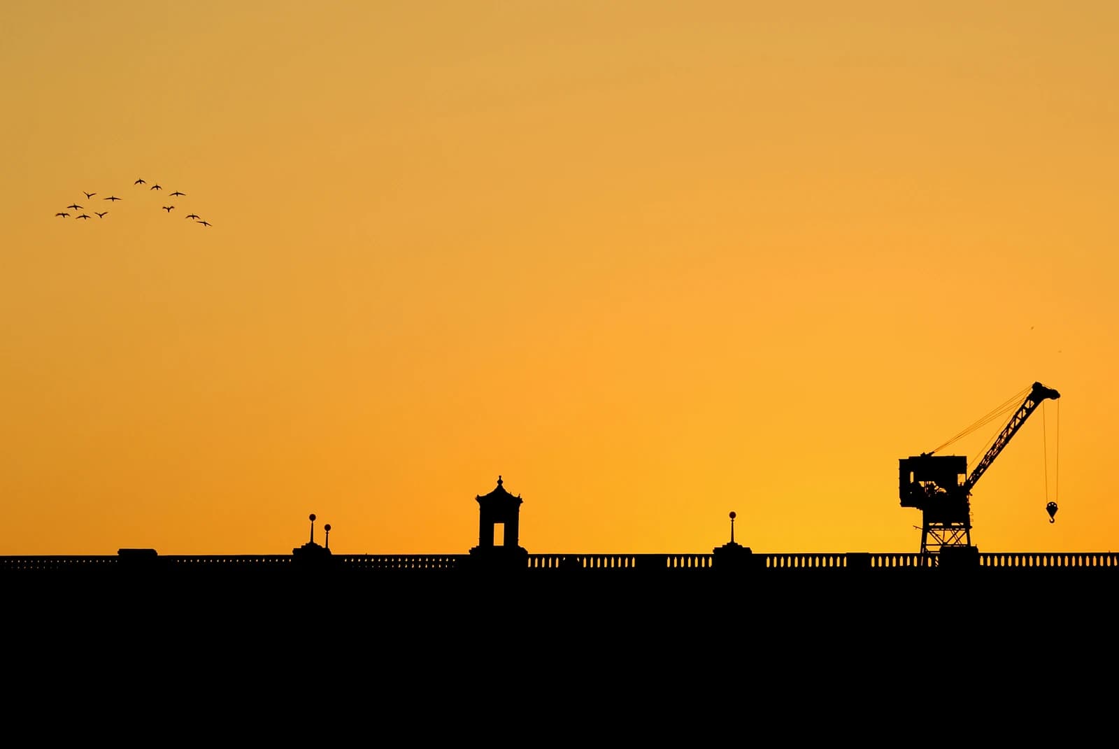 Silhouette of the Krishna Raja Sagara Dam showing its structure and a crane.