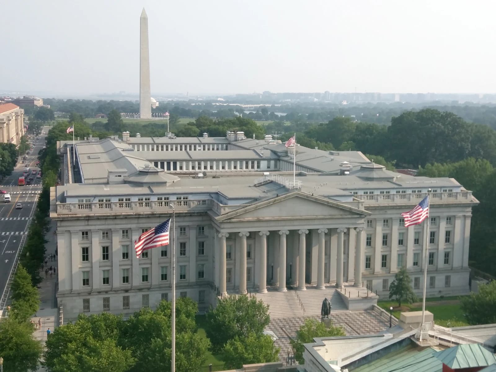 United States Treasury Building, with large columns and an American flag flying prominently.