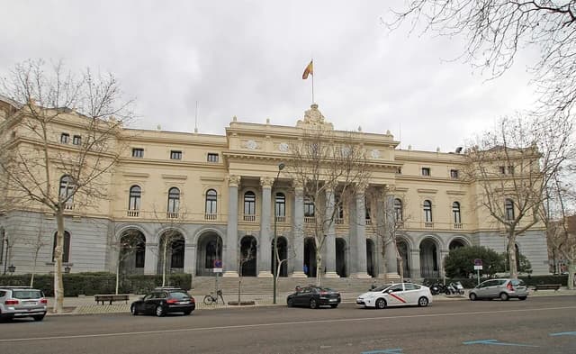 Palace of the Madrid Stock Exchange, Spain, with cars parked along the street.