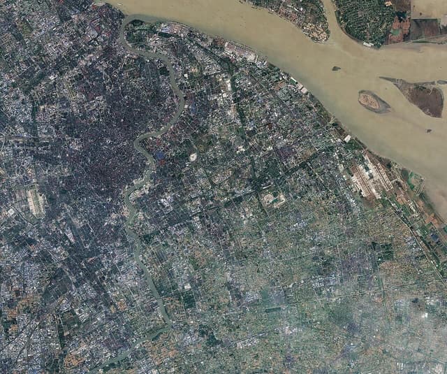 Satellite image showing the urban landscape of Shanghai and its surrounding river.