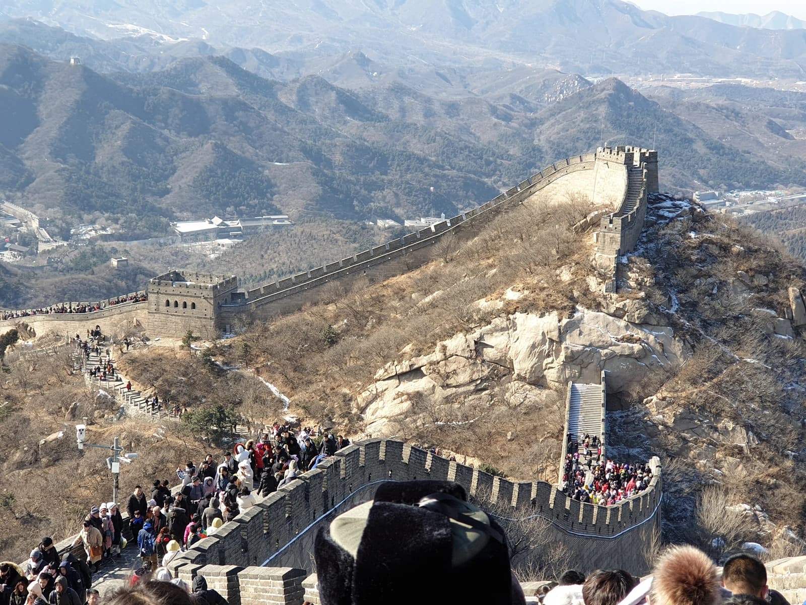 Tourists walking along the Great Wall of China, a long stone wall.