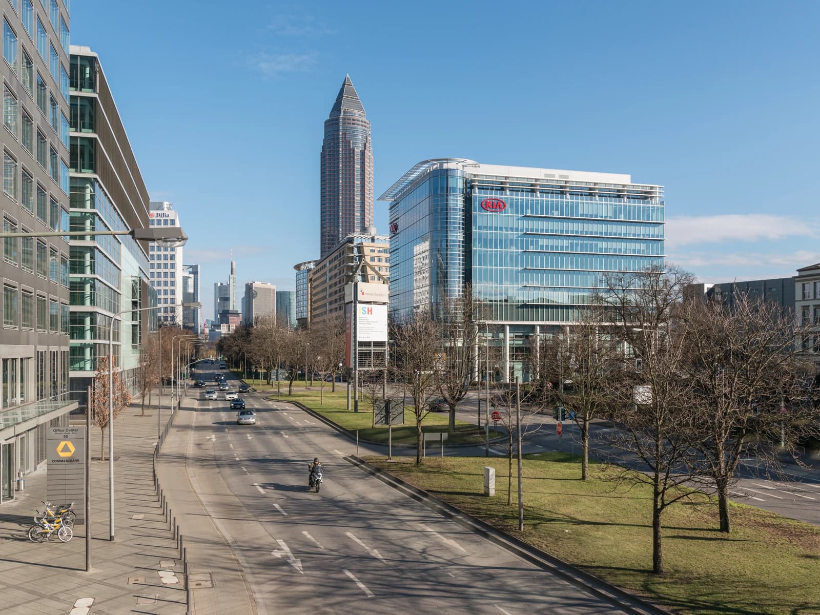 Theodor-Heuss-Allee in Frankfurt, Germany, with modern buildings and a street.