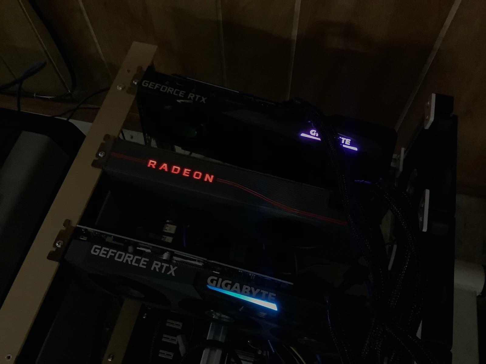 Cryptocurrency mining rig with multiple graphics cards glowing in a dark room.