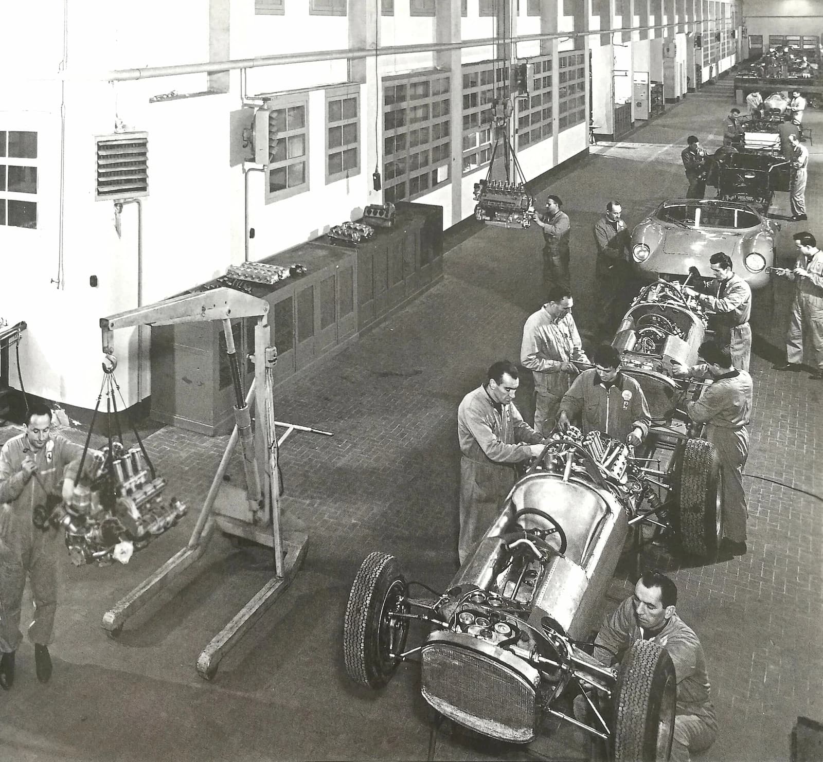 Mechanics assembling cars inside the Ferrari factory in Maranello during the 1960s.