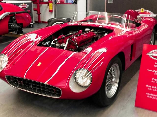 Red Ferrari 500 TRC sports car with the hood open, revealing the engine.