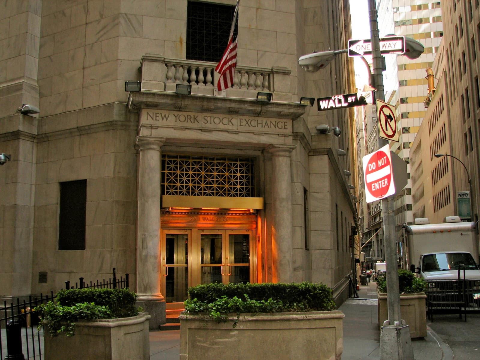 New York Stock Exchange building facade and Wall Street sign in New York City.