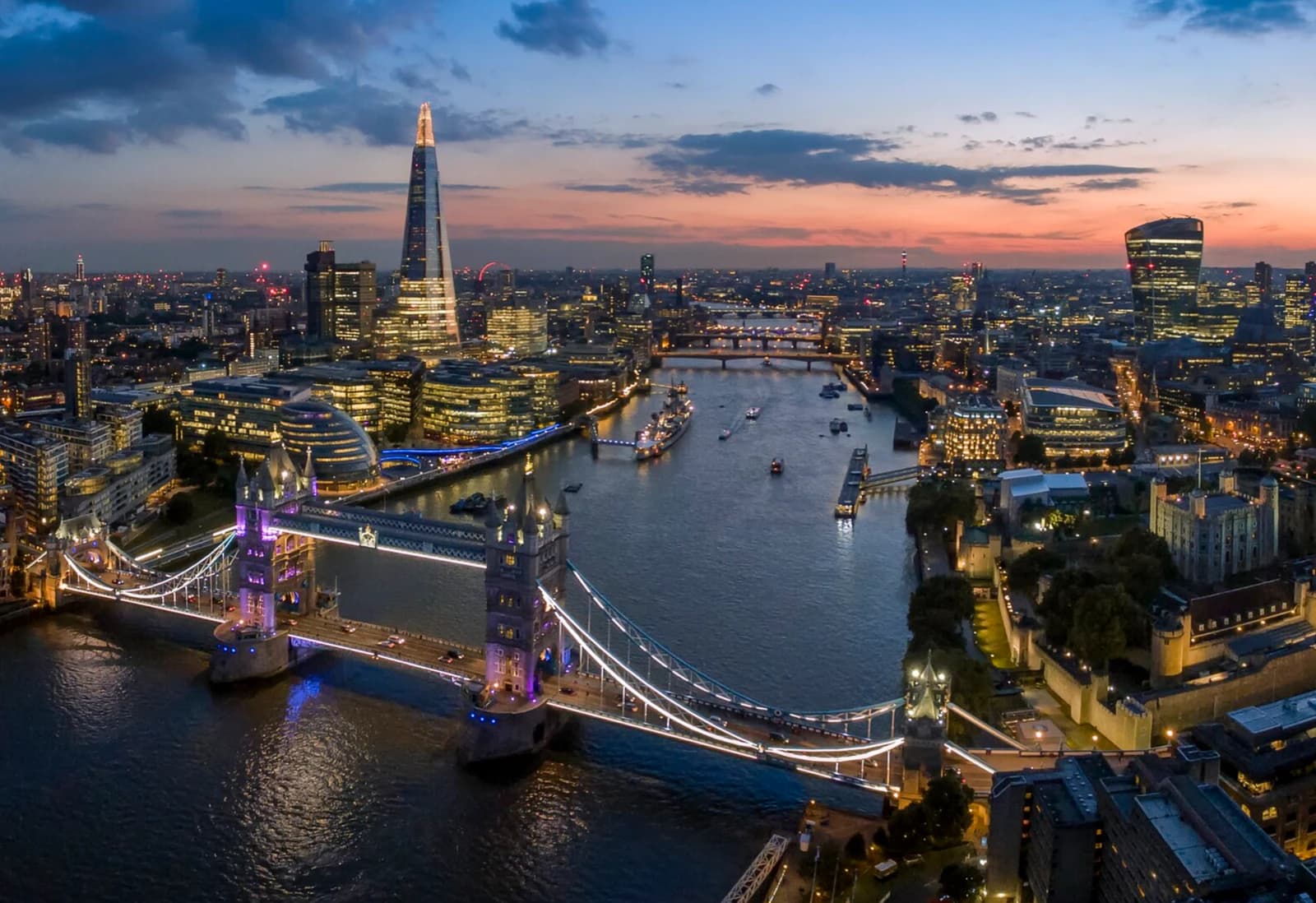 An aerial view of the London skyline at dusk with iconic landmarks.