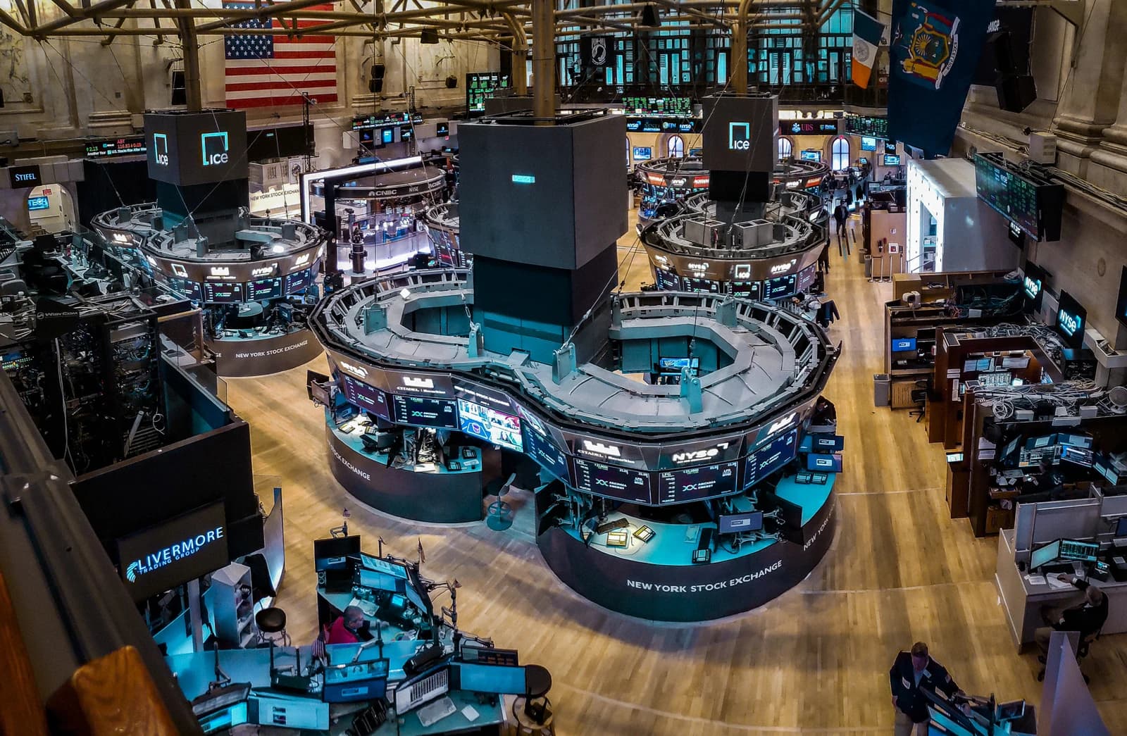 Overview of the New York Stock Exchange trading floor with screens and workstations.