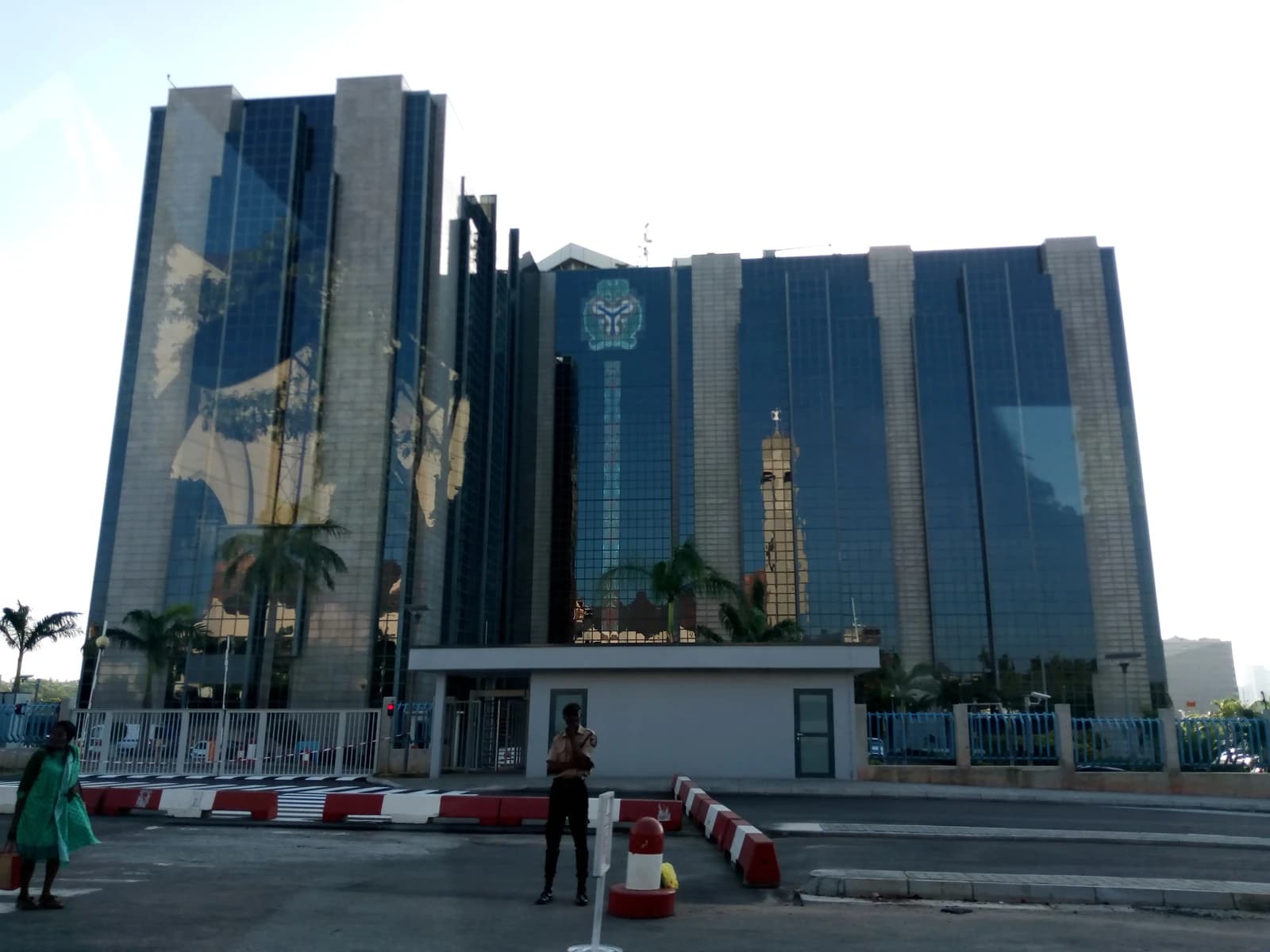 Exterior view of the Central Bank of Nigeria building in Abuja, showcasing its glass facade.