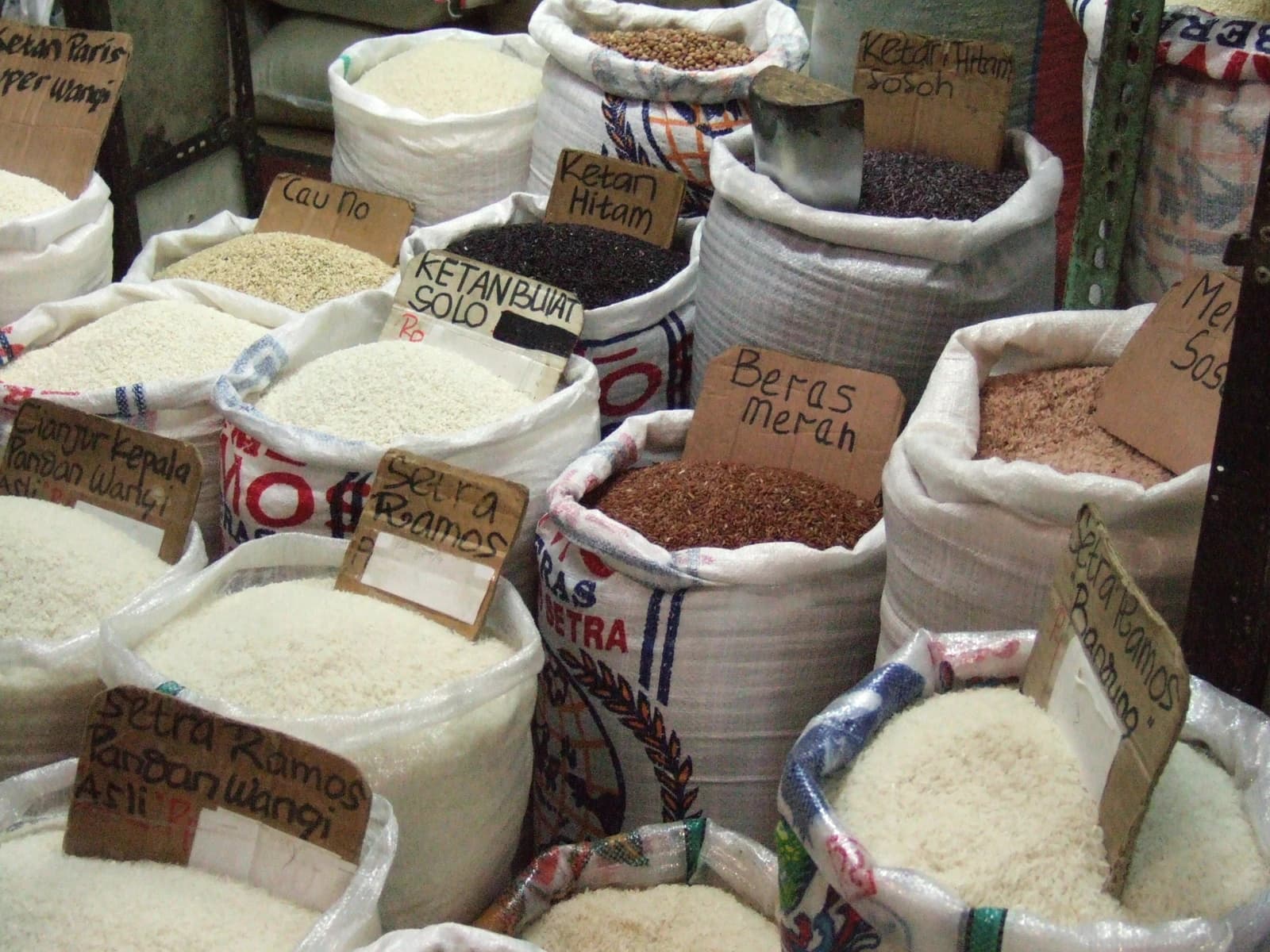 Sacks of different varieties of rice displayed for sale at an Indonesian market.