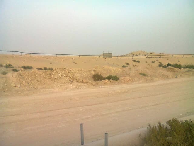 Oil pipelines running through a desolate sandy desert in Saudi Arabia.