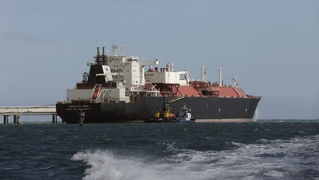 Large ship 'Catalunya Spirit' being assisted by tugboats on rough seas.