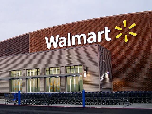 Exterior of a Walmart store with its large white and yellow logo.