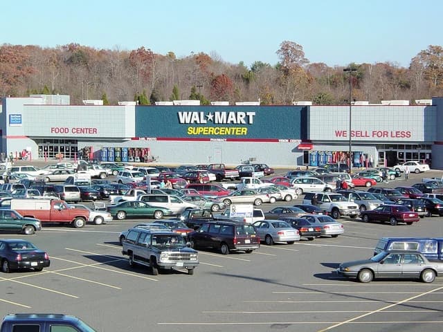 Exterior view of a Wal-Mart Supercenter building with a parking lot full of cars.