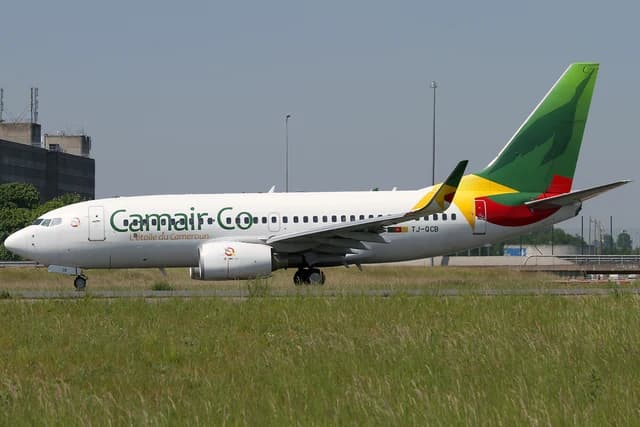 Camair-Co Boeing 737-700, registration TJ-QCB, on a runway at Charles de Gaulle Airport.